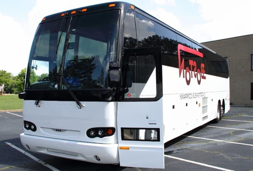A br和ed Boston Charter Bus Company charter bus parks in an empty parking lot, 门大开，方便乘客登机